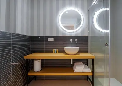 a bathroom with a sink and a glass shower at Hotel Condado Ourense in Ourense