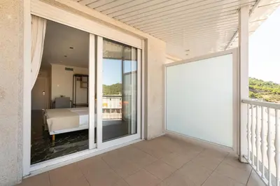 a large sliding glass door to a balcony with a bed at Hotel Condado Ourense in Ourense