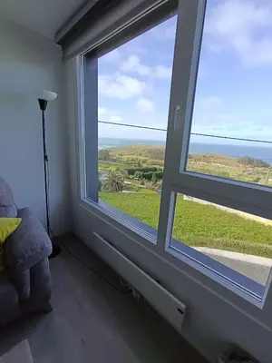 a bathroom with a window with a view of the ocean at O Chaleco in San Ciprián