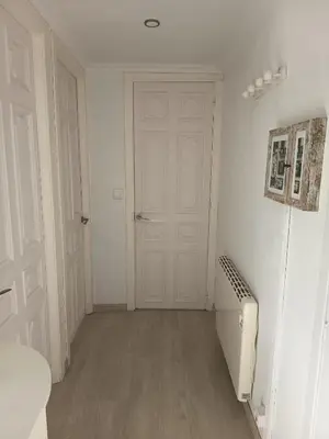a room with white cabinets and a television on a wall at O Chaleco in San Ciprián