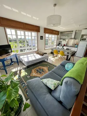 a living room with a blue couch and a kitchen at Casa Lola in Teo