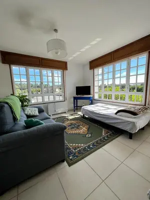 a living room with a couch and a bed at Casa Lola in Teo