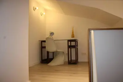 a white chair sitting in a room with a desk at CASA REHABILITADA EN CASCO HISTÓRICO in Santiago de Compostela
