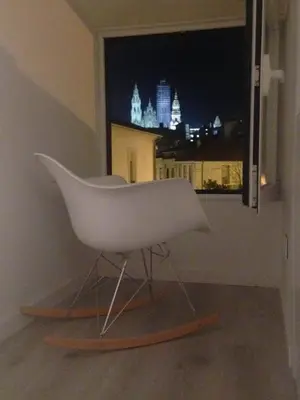 a white chair sitting in front of a window at CASA REHABILITADA EN CASCO HISTÓRICO in Santiago de Compostela