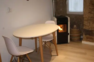 a table and chairs in a room with a fireplace at CASA REHABILITADA EN CASCO HISTÓRICO in Santiago de Compostela
