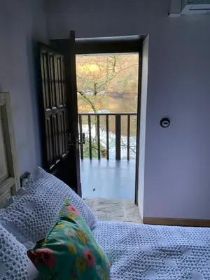a bedroom with a bed and a door to a balcony at Casa Escondida Aveiga in Chantada