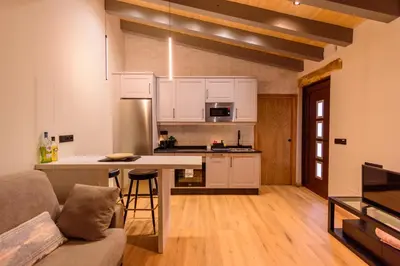 a kitchen with white cabinets and a table in a room at Casa Escondida Aveiga in Chantada