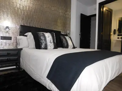 a bedroom with a large bed with black and white pillows at HOTEL TERRA GALEGA MEIGA in Monforte de Lemos