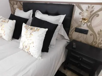 a bedroom with a white bed with black and white pillows at HOTEL TERRA GALEGA MEIGA in Monforte de Lemos