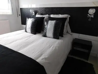 a bedroom with a large bed with black and white pillows at HOTEL TERRA GALEGA MEIGA in Monforte de Lemos