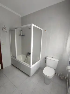 a white bathroom with a toilet and a shower at CASA DE MELCHOR in Cruces