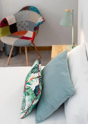two pillows sitting on a bed next to a chair at Hostal Santa Cruz in Santiago de Compostela