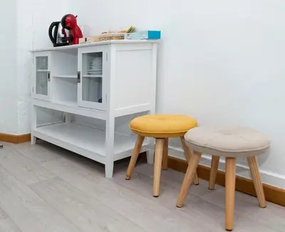 a white cabinet and two stools in a room at Hostal Santa Cruz in Santiago de Compostela