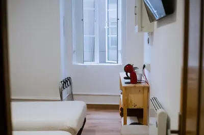 a hospital room with a bed and a window at Hostal Santa Cruz in Santiago de Compostela