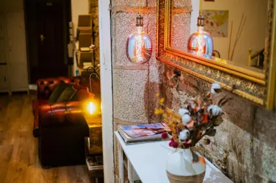 a room with a mirror and a vase with flowers on a table at Hostal Santa Cruz in Santiago de Compostela
