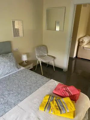 a bedroom with a bed and a chair and a mirror at Villa Bimba, alojamiento con piscina y barbacoa in Caldas de Reis