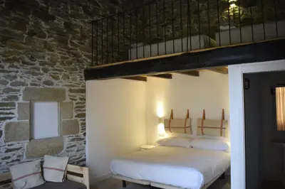two beds in a room with a brick wall at CASA SOLANCE in Sarria