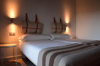 two beds in a room with lights on the wall at CASA SOLANCE in Sarria