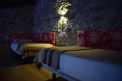 two beds in a room with a stone wall at CASA SOLANCE in Sarria