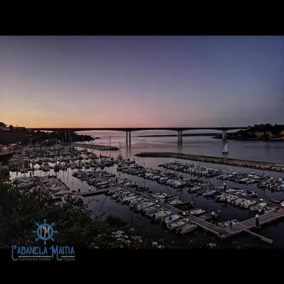 a group of boats parked in a marina near a bridge at Cabanela Maitia Apto Telmo Duplex in Ribadeo