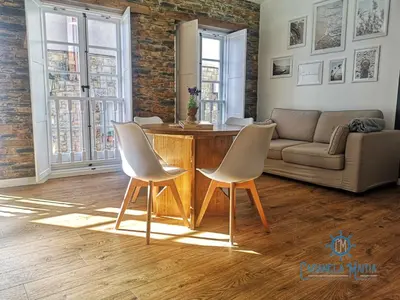 a living room with two chairs and a table at Cabanela Maitia Apto Telmo Duplex in Ribadeo