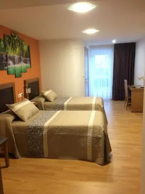 a hotel room with two beds in a room at Habitaciones A Casa de Pepe in Tríacastela