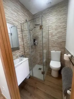 a bathroom with a toilet and a glass shower at Habitaciones A Casa de Pepe in Tríacastela