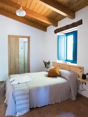 a bedroom with a large bed and a window at CASA TERRA ALMA in Laza