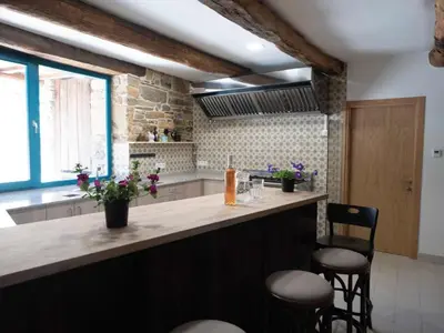 a kitchen with a counter with two chairs and a counter top at CASA TERRA ALMA in Laza