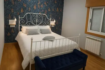 a bedroom with a bed and a blue bench at CHALET A SOLO 5 MIN DE OURENSE CIUDAD con jardín y barbacoa in Ourense
