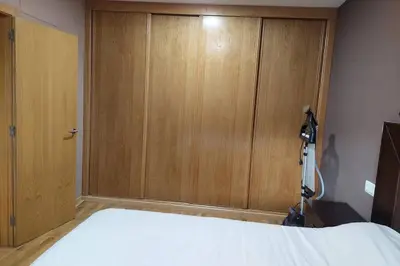 a bedroom with a large wooden cabinet next to a bed at CHALET A SOLO 5 MIN DE OURENSE CIUDAD con jardín y barbacoa in Ourense
