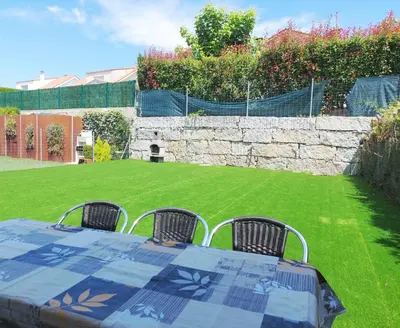 a table with four chairs in a yard at CHALET A SOLO 5 MIN DE OURENSE CIUDAD con jardín y barbacoa in Ourense