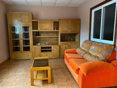 a living room with an orange couch and a table at Fonte do Torno in A Coruña