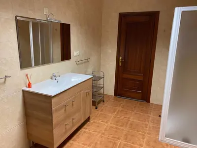 a bathroom with a sink and a mirror and a door at Fonte do Torno in A Coruña