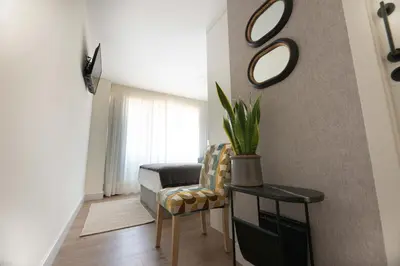 a living room with a chair and a mirror at LA CASITA DE FINA in Caldas de Reis