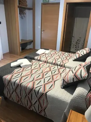two beds sitting next to each other in a bedroom at Pensión Santirso in Palas de Rei
