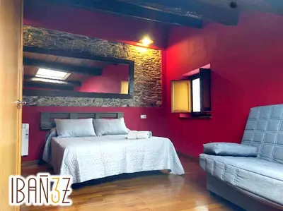 a red bedroom with a bed and a couch at Ibañez 3 in Ribadeo