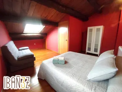 a bedroom with red walls and a bed and a chair at Ibañez 3 in Ribadeo