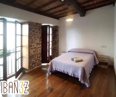 a bedroom with a bed in a room with wooden floors at Ibañez 3 in Ribadeo