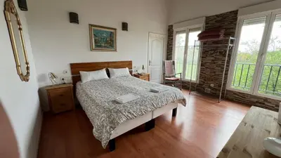 a bedroom with a bed and a wooden floor at CASAPUEBLO Arzúa in Campo