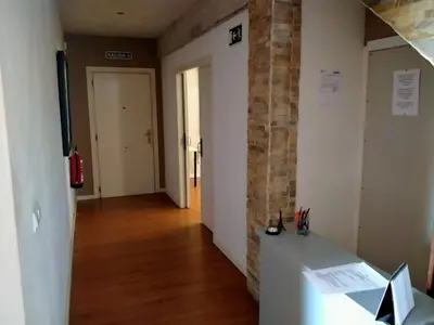 a hallway with a brick wall and a desk in a room at CASAPUEBLO Arzúa in Campo