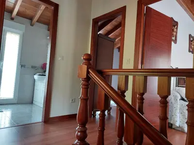 a wooden staircase in a home with a mirror at O Cobo Vacacional in Padrón