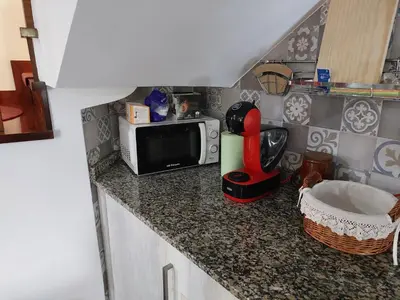 a kitchen with a counter with a microwave and a mixer at O Cobo Vacacional in Padrón