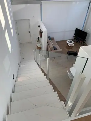 a white staircase in a living room with a glass railing at OKTHEWAY PERBES HOUSE in A Coruña