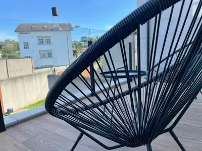 a black bench sitting on top of a roof at OKTHEWAY PERBES HOUSE in A Coruña