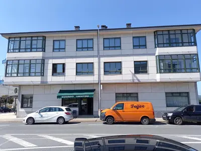 an orange van parked in front of a building at Hostal Carpinteiras in Rodeiro