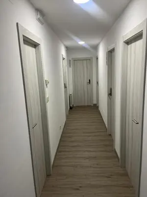 a hallway with white walls and wooden floors and doors at Hostal Carpinteiras in Rodeiro