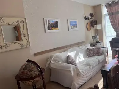 a living room with a white couch and a mirror at O Xuncal in Barreiros