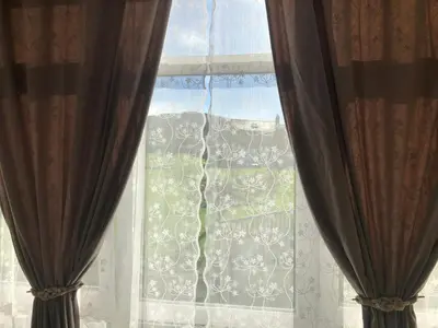 a window with curtains and a view of a yard at O Xuncal in Barreiros