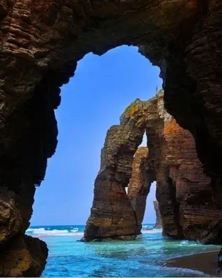 an arch in a rock formation in the ocean at O Xuncal in Barreiros